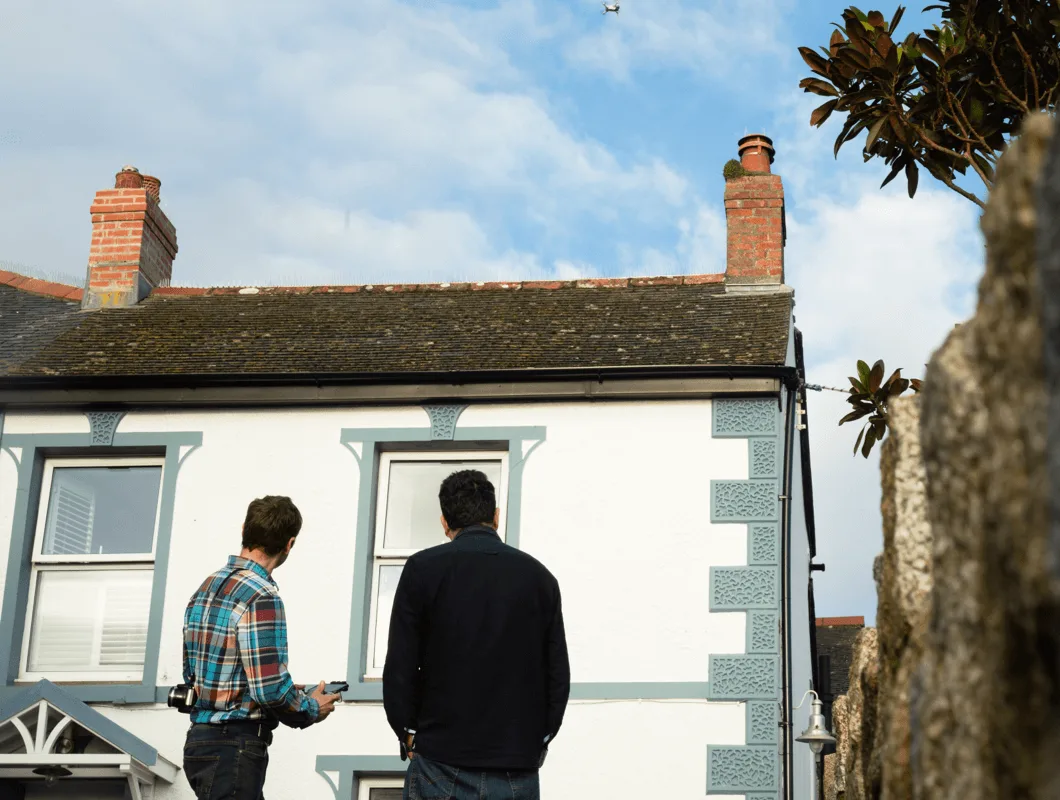 JCS Page and a client watching a drone survey a rooftop together