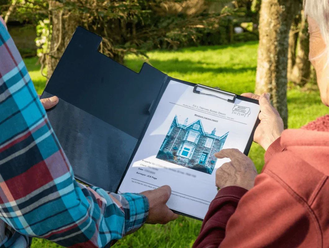 A client reviewing a Muddy Mortars survey report with JCS Page