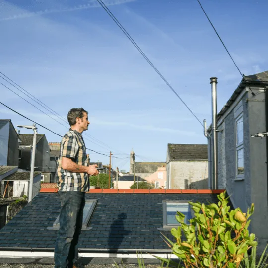Muddy Mortars surveyor flying a drone survey over rooftops in Cornwall