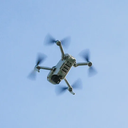 Close-up of the survey drone in flight against a clear sky